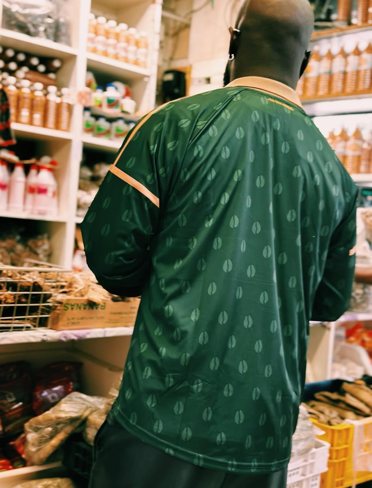 Person wearing a green patterned shirt in a store aisle